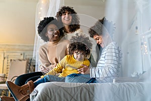 Happy multiethnic family. Smiling gay women couple spending time together with children at home.