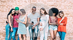 Happy multiethnic friends using smartphone at university college backyard - Young people on addict mood with mobile smart phones