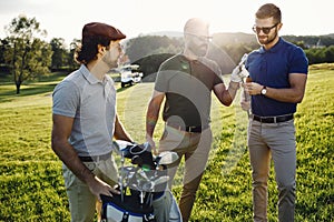 Happy multiethnic golfers spending time together in golf course