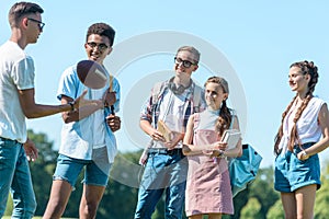 happy multiethnic teenagers playing with rugby ball