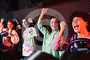 happy multiethnic teenagers showing win gesture