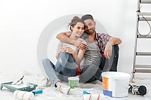 Happy multiethnic young couple renovating home and hugging