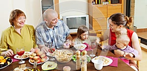 Happy multigeneration family communicate over table