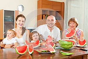Happy multigeneration family eating watermelon