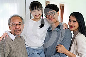 Happy multigenerational asian family portrait in living room