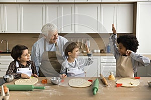 Happy multigenerational family cooking together in cozy domestic kitchen