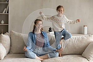 Happy multigenerational family doing yoga exercises at home.