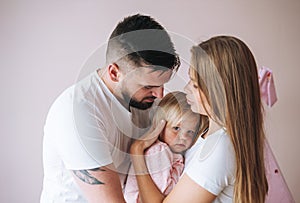 Happy multinational family father young man and mother with baby girl little daughter having fun in children room at home