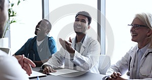 Happy multinational young and mature GP professionals communicating during seminar