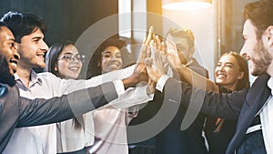 Happy multiracial business team giving high fives