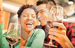 Happy multiracial couple drinking red wine at fashion bar