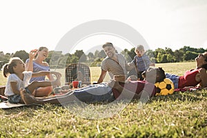 Happy multiracial families doing picnic outdoor in city park during summer vacation - Main focus child boy