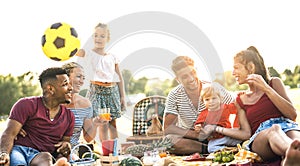 Happy multiracial families having fun together with kids at pic nic barbecue party - Multicultural joy and love concept