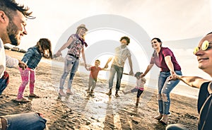 Šťastný mnohorasový rodiny kolem tanec na pláž na západ slunce 