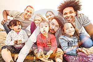 Happy multiracial families taking selfie at beach making funny faces