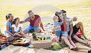 Happy multiracial families taking selfie at pic nic garden party - Multicultural joy and love concept with mixed race people