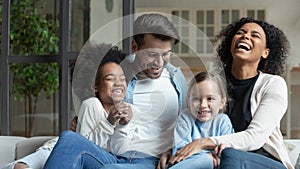 Happy multiracial family with little daughters relax at home