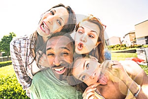 Happy multiracial friends group taking selfie sticking tongue out with funny faces - Young people sharing stories on social