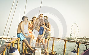 Happy multiracial friends having fun on sailing party boat