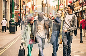 Happy multiracial friends walking on Brick Lane at Shoreditch London