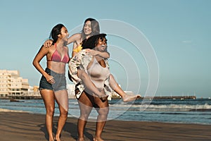 Happy multiracial girls with different body size having fun on the beach during summer holiday