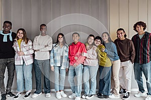 Happy multiracial group of teenagers having fun inside university photo