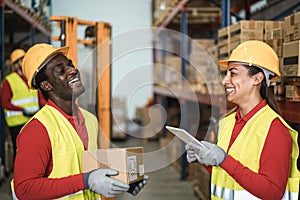 Happy multiracial workers having fun inside warehouse - Focus on woman face