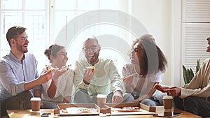 Happy multiracial young people group laughing eating pizza indoors