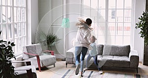 Happy mum and child daughter having fun in living room