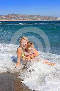 Happy mum with daughter have rest on the sea