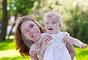 Happy mum and her Child playing in Park together.