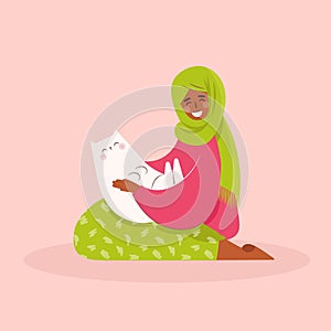 Happy muslim arabic woman with cat . Female holding cat on knees and petting it. Pet ownership, pet parent. Happy Mew Year and