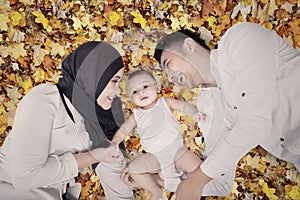 Happy muslim family on autumn leaves