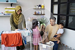 Happy muslim family doing laundry at home