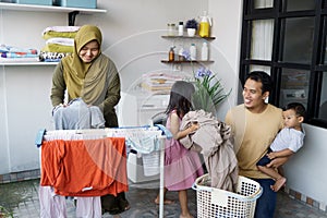 Happy muslim family doing laundry at home