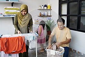 Happy muslim family doing laundry at home