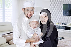 Happy muslim family and their son smiling at home