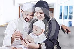 Happy muslim family use cellphone at home