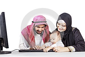 Happy muslim family using a computer together photo