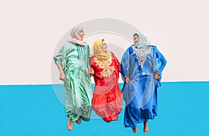 Happy Muslim girls jumping together outdoor - Arabian women having fun in the college