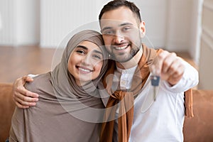 Happy Muslim Spouses Showing New House Key Embracing At Home
