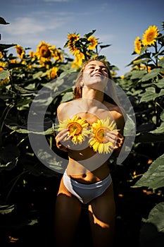 Happy Naked Blonde Woman In A Field Of Sunflowers.