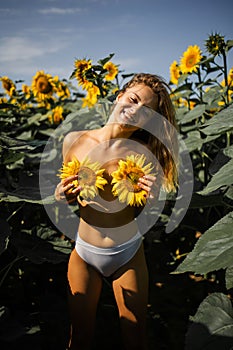 Happy Naked Blonde Woman In A Field Of Sunflowers.