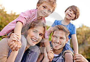 Happy, nature and children on parents shoulders in outdoor park or field for playing together. Smile, bonding and