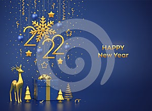 Happy New 2022 Year. Hanging golden metallic numbers 2022 with snowflake, stars, balls on blue background. Gift box, gold deer and