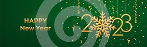 Happy New 2023 Year. Hanging Golden metallic numbers 2023 with shining snowflake and confetti on green background. New Year