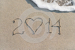 Happy New Year 2014 on the sea sandy beach with heart, love conc