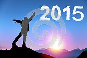 Happy new year 2015. young man standing on the top of mountain