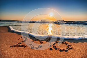 Happy New Year 2018 concept, lettering on the beach. Sea sunrise