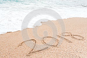 Happy new year 2018 concept. Number 2018 written on sandy beach